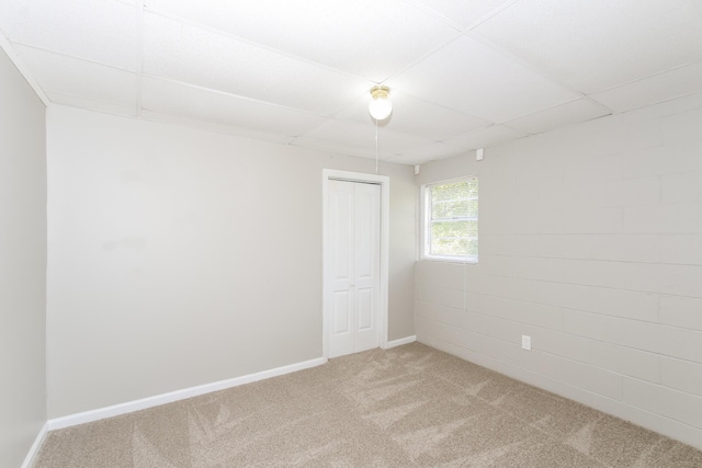 spare room featuring a drop ceiling and carpet floors