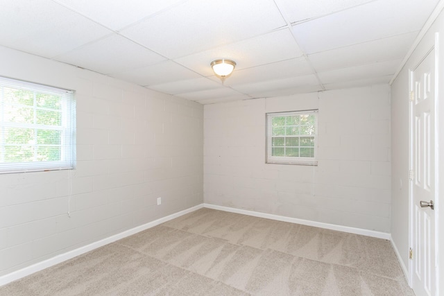 carpeted empty room featuring a drop ceiling