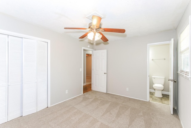 unfurnished bedroom with connected bathroom, a closet, ceiling fan, and light colored carpet