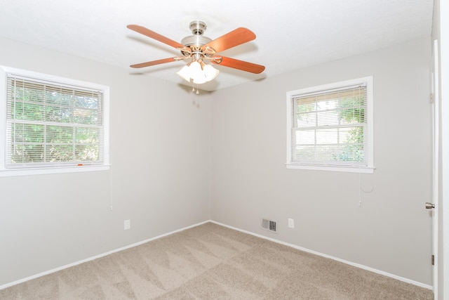 carpeted empty room featuring plenty of natural light and ceiling fan