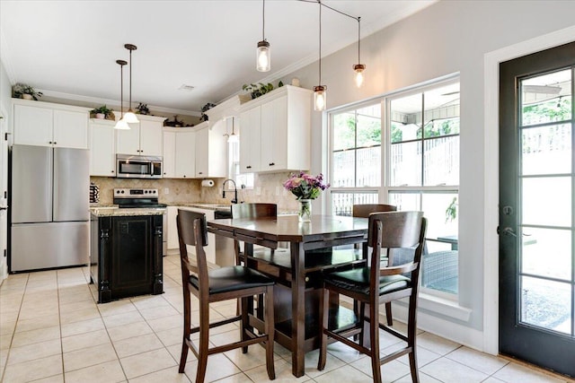 945 Watermark Dr, Evans, GA 30809 - kitchen with stainless steel appliances, light tile patterned floors, ornamental molding, backsplash, and plenty of natural light