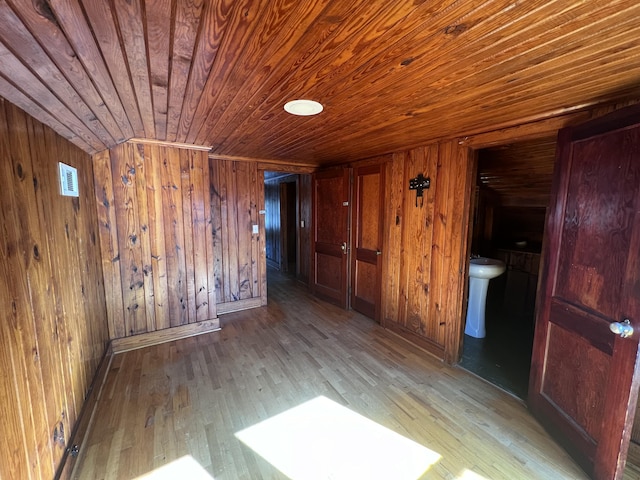 spare room with light hardwood / wood-style flooring, wood ceiling, and wood walls