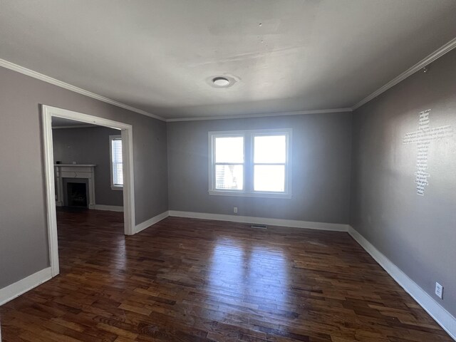 empty room featuring dark hardwood / wood-style flooring, plenty of natural light, and ornamental molding