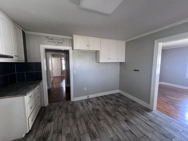 kitchen featuring dark hardwood / wood-style floors, white cabinetry, and ornamental molding