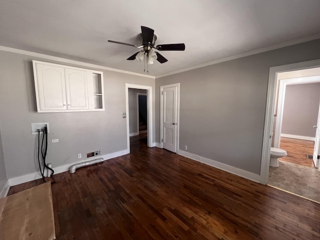 unfurnished bedroom featuring ceiling fan, ensuite bathroom, ornamental molding, and dark wood-type flooring