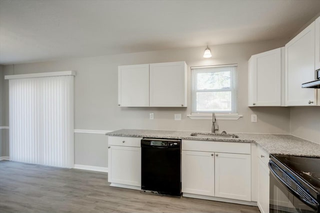 kitchen with light stone countertops, black appliances, white cabinetry, light hardwood / wood-style floors, and sink