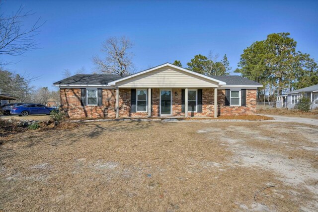 single story home with covered porch and brick siding