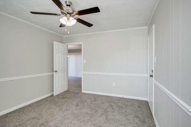 carpeted empty room featuring ceiling fan and ornamental molding