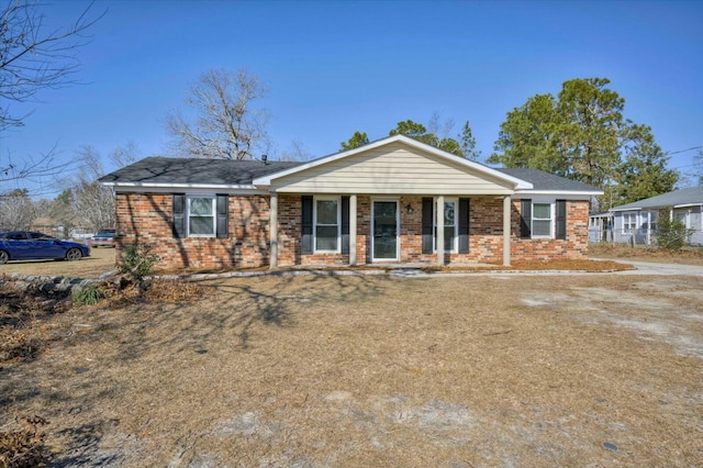 ranch-style house featuring brick siding and covered porch