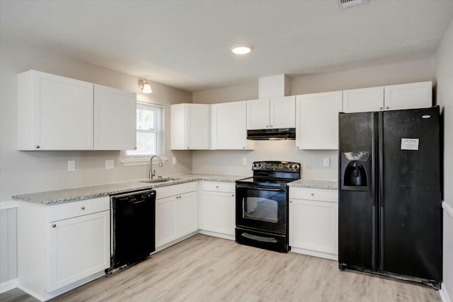 kitchen featuring sink, white cabinets, light stone countertops, light hardwood / wood-style floors, and black appliances