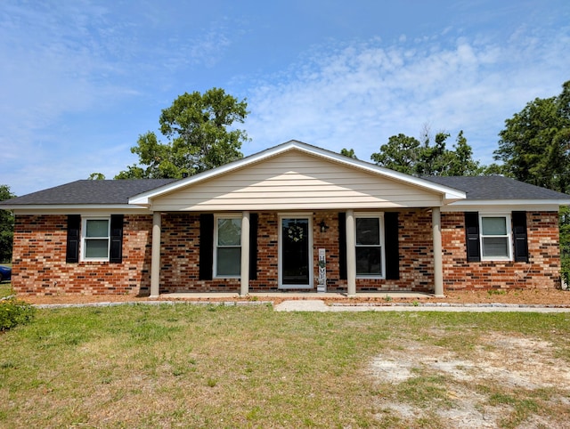 single story home with covered porch, brick siding, and a front yard