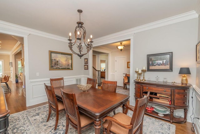 295 River Wind Dr, North Augusta, SC 29841 - dining space featuring ornamental molding, a chandelier, light wood-type flooring, a wainscoted wall, and a decorative wall