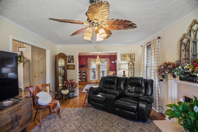 living room featuring hardwood / wood-style floors, ceiling fan with notable chandelier, a textured ceiling, and ornamental molding