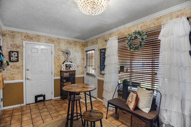 dining space with a textured ceiling, a notable chandelier, light tile patterned floors, and ornamental molding