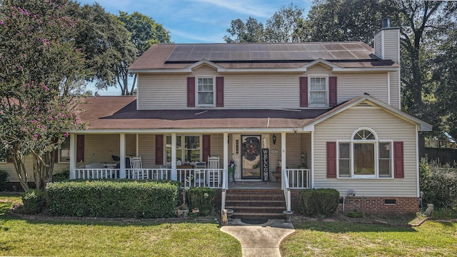 view of front of home with solar panels, covered porch, and a front lawn