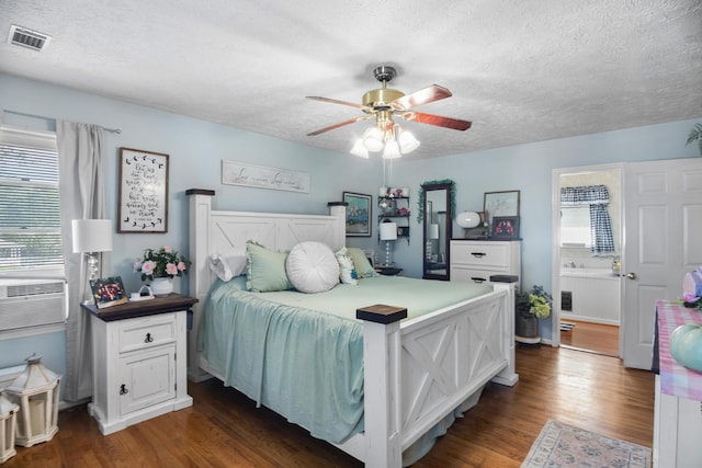 bedroom with ceiling fan, dark hardwood / wood-style flooring, and a textured ceiling