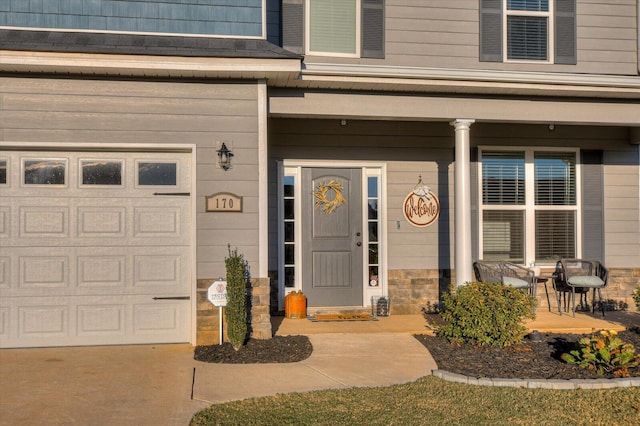 doorway to property with a porch and a garage