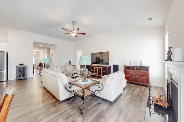 living room featuring a wealth of natural light, ceiling fan, wood-type flooring, and lofted ceiling