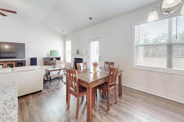 dining area with ceiling fan, dark hardwood / wood-style flooring, plenty of natural light, and vaulted ceiling