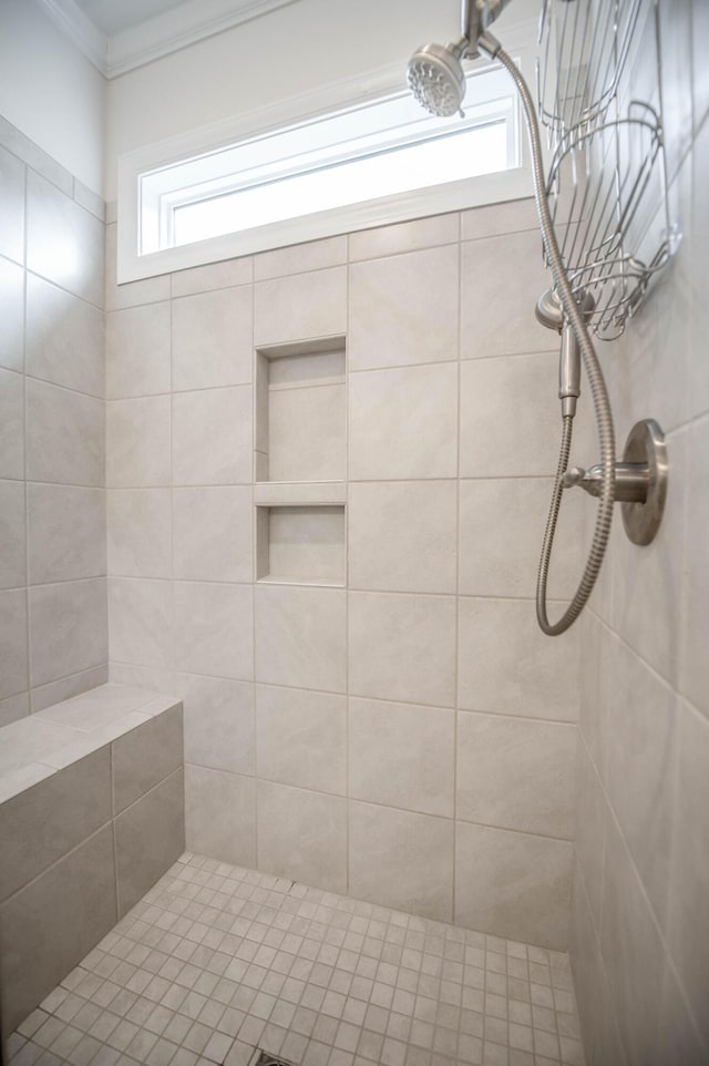 bathroom with a tile shower and ornamental molding