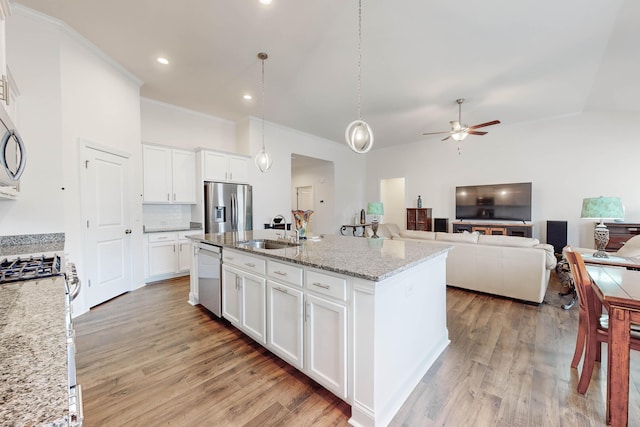 kitchen featuring light stone countertops, white cabinetry, an island with sink, and stainless steel appliances