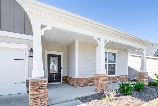 entrance to property with covered porch and a garage