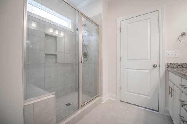 bathroom featuring tile patterned flooring, vanity, and an enclosed shower