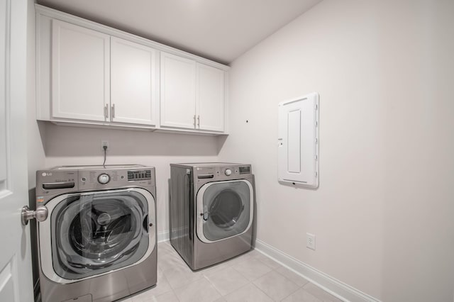 laundry room with light tile patterned floors, cabinets, independent washer and dryer, and electric panel