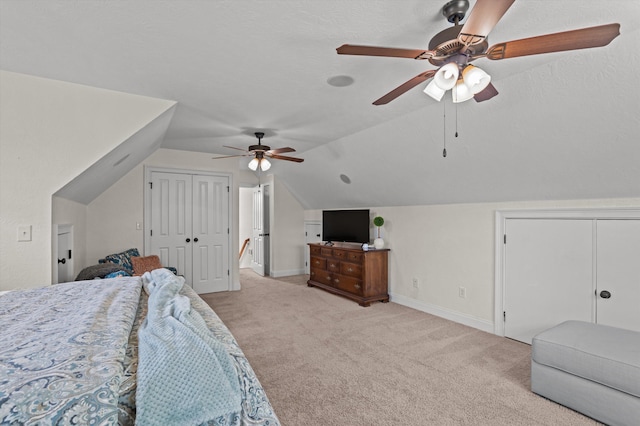 bedroom with light colored carpet, lofted ceiling, baseboards, and a ceiling fan
