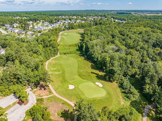 aerial view of property and surrounding area featuring a golf course and nearby suburban area