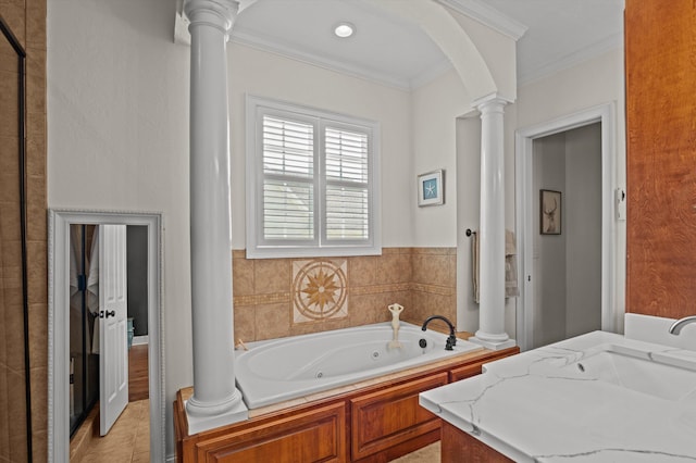 bathroom featuring decorative columns, ornamental molding, a jetted tub, and a sink
