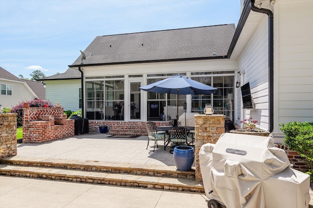 view of patio featuring a sunroom and a grill