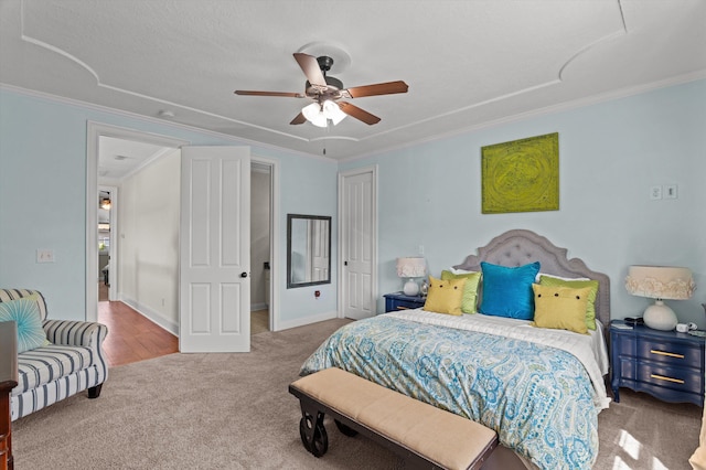 carpeted bedroom featuring crown molding, a closet, and ceiling fan