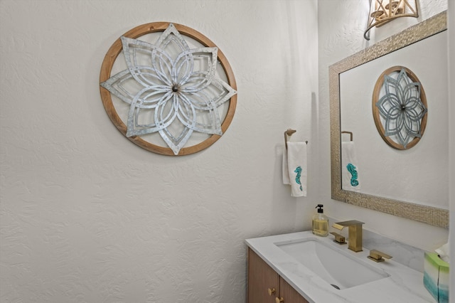 bathroom featuring vanity and a textured wall
