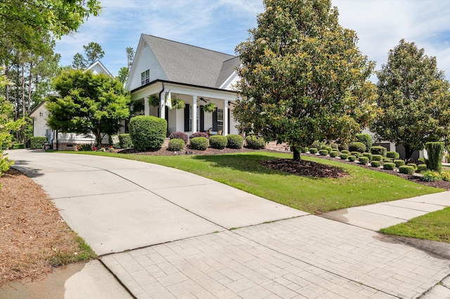 view of front of property with a front yard, a porch, and a shingled roof