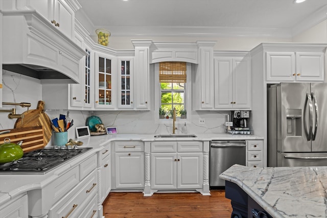 kitchen with stainless steel appliances, a sink, custom exhaust hood, white cabinets, and recessed lighting