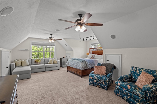 bedroom featuring carpet, vaulted ceiling, multiple windows, a textured ceiling, and ceiling fan