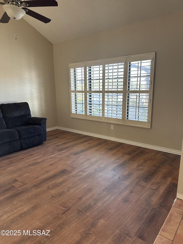 living room featuring a textured ceiling, dark wood-type flooring, lofted ceiling, and ceiling fan