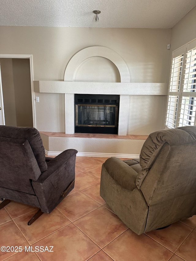 tiled living room featuring a textured ceiling