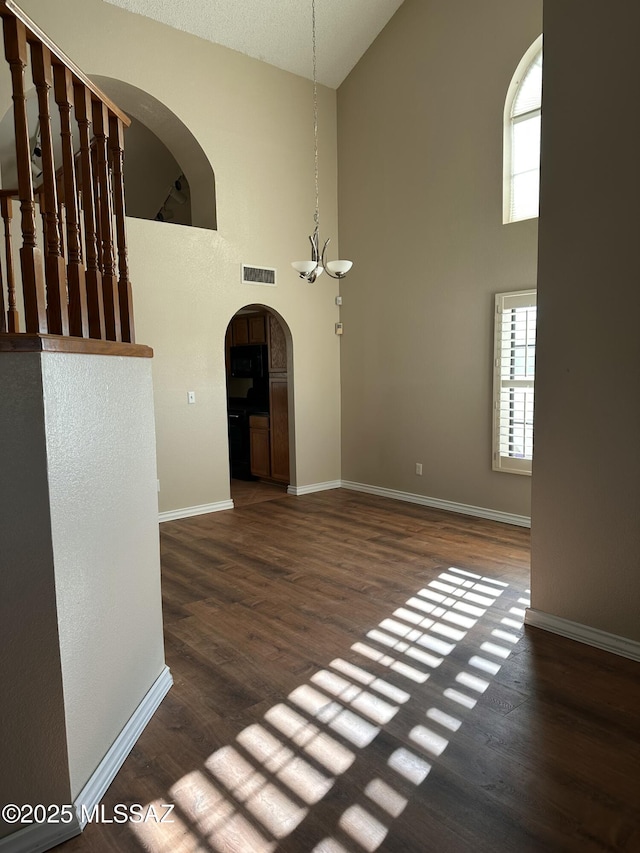 unfurnished living room featuring dark hardwood / wood-style floors and a high ceiling