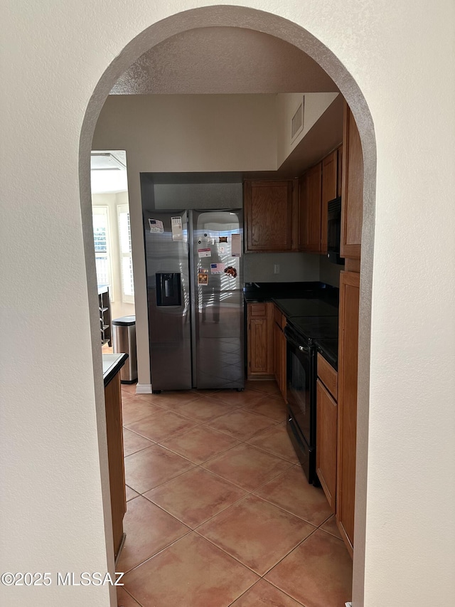 kitchen with black appliances and light tile patterned floors