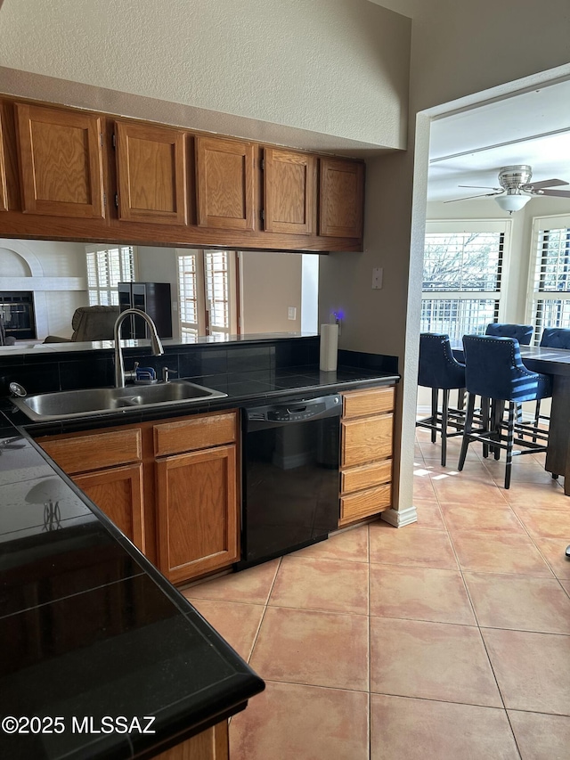 kitchen with ceiling fan, sink, black dishwasher, and light tile patterned flooring