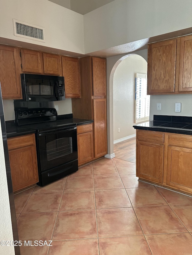 kitchen with light tile patterned floors and black appliances