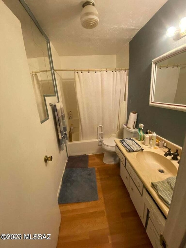 full bathroom featuring shower / bathtub combination with curtain, vanity, toilet, and hardwood / wood-style floors