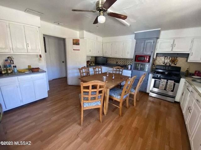 kitchen featuring stainless steel stove, ceiling fan, and dark hardwood / wood-style flooring