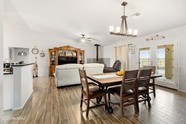 dining area featuring dark hardwood / wood-style flooring, french doors, vaulted ceiling, and ceiling fan with notable chandelier