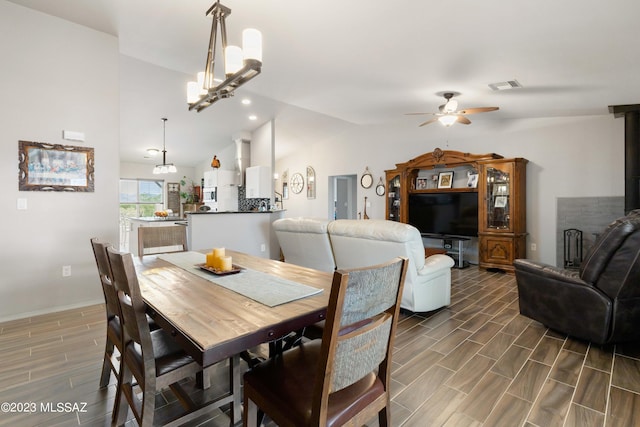 dining space featuring lofted ceiling and ceiling fan with notable chandelier