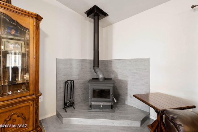 interior space with dark wood-type flooring and a wood stove