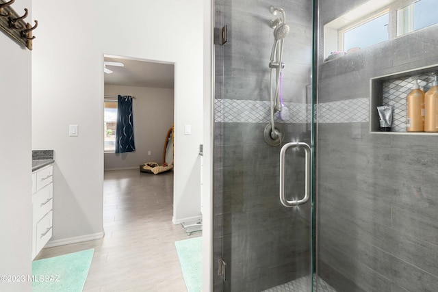 bathroom featuring ceiling fan, vanity, and an enclosed shower