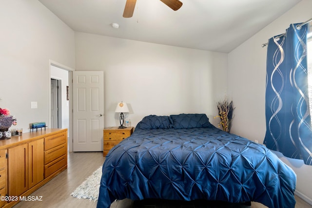 bedroom with ceiling fan, lofted ceiling, and light wood-type flooring